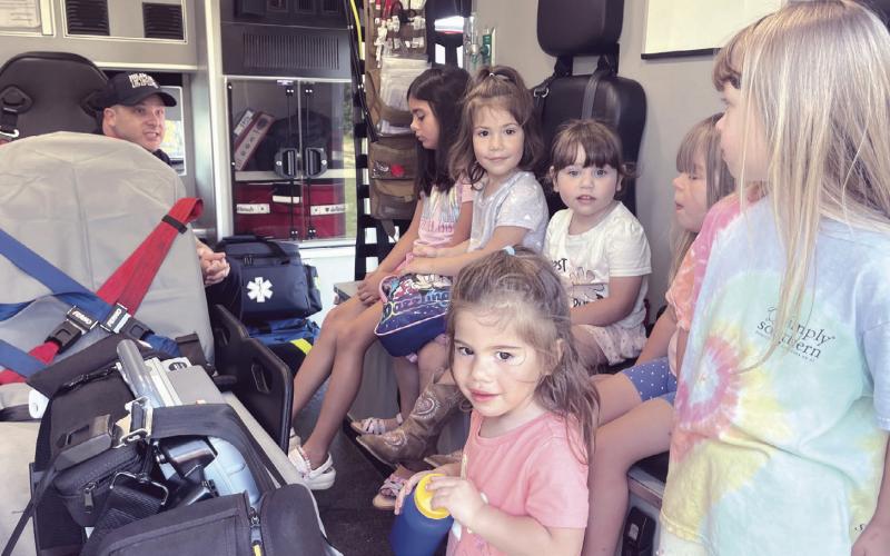 LOTS OF TRUCKS— Lucy Hill Patterson Memorial Library held its annual Touch -A-Truck event to kick off its summer reading program on Friday in the East Bell Taphouse parking lot in association with the Rockdale Police Department, the City of Rockdale’s Public Works Department, Rockdale Volunteer Fire Department and Allegiance Mobile Health. Here some youngsters are finding out what is inside an ambulance.