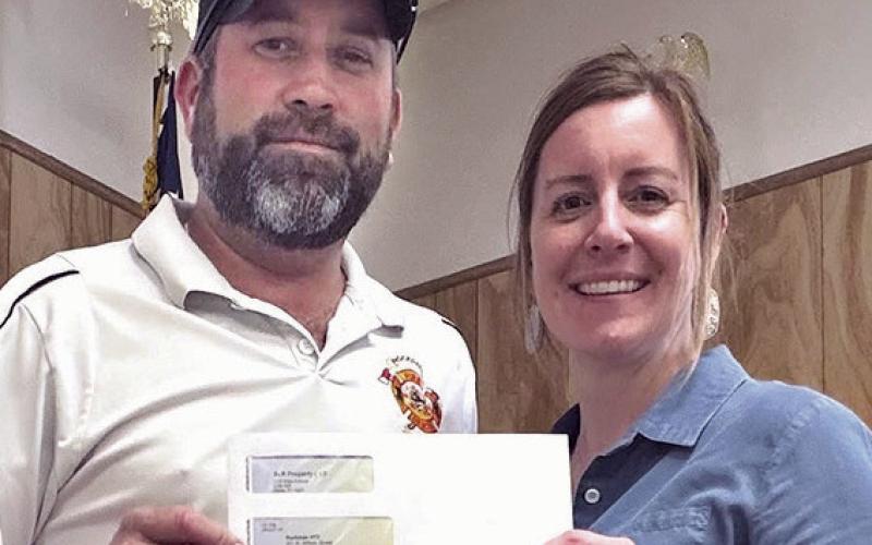 RVFD DONATIONS— Fire Chief James McQuinn accepts a $2,000 donation from Business Systems and Communications Associate Kayla Schnell. The volunteer fire department also recently received $15,000 from Cappolino | Dodd | Krebs LLP, $1,000 from Dale Throckmorton, and $1,500 from Pete and Nancy Zenner.