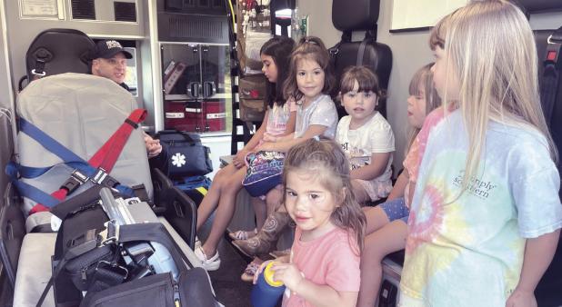 LOTS OF TRUCKS— Lucy Hill Patterson Memorial Library held its annual Touch -A-Truck event to kick off its summer reading program on Friday in the East Bell Taphouse parking lot in association with the Rockdale Police Department, the City of Rockdale’s Public Works Department, Rockdale Volunteer Fire Department and Allegiance Mobile Health. Here some youngsters are finding out what is inside an ambulance.