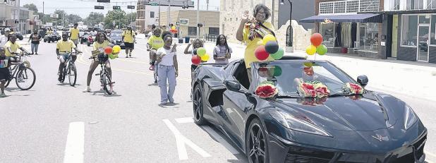CELEBRATING FREEDOM— Rockdale’s Juneteenth Parade Grand Marshall Freddie Robertson waves to the crowd on Saturday as the parade wound down Cameron Avenue on its way to Sumuel Park. At the park were food, drinks, bounce houses, water slides and music to enjoy. Parade organizers Kendra Darnell Lewis and Larry Wilcox had more participants in the parade than in years past. See more photos on page 10A.
