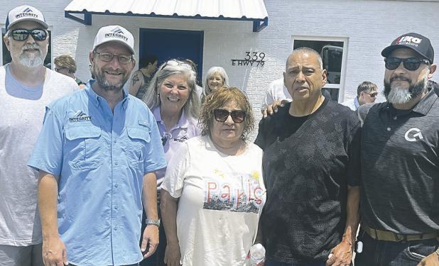ROOF WINNERS— Rosa and Jesus Garcia were the lucky winners of a brand-new roof from Integrity Roofing at Thursday’s ribbon cutting ceremony, and work on the roof started the very next morning. Shown here (L-R) are Integrity Roofing owners Clint Cox, John Marshall, Debra Jo Cooper, the Garcias, and Vic Salcedo, Territory Sales Manager for Cameron Ashley Building Products who donated the shingles for the project.