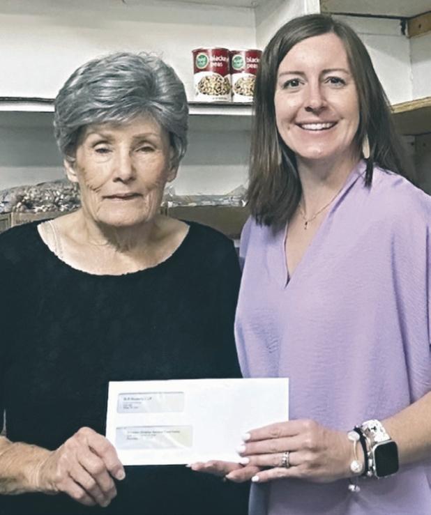 Patsy Brymer, left, Rockdale Christian Services food pantry director and board president, accepts a $5,000 donation from Kayla Schnell, Sandow Lakes Ranch Business Systems and Communications Associate.