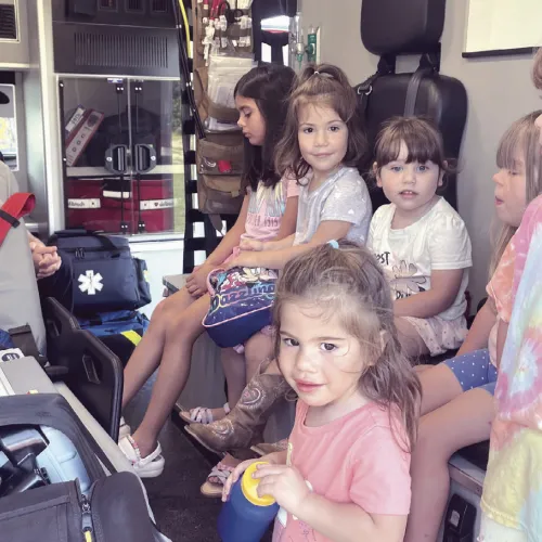 LOTS OF TRUCKS— Lucy Hill Patterson Memorial Library held its annual Touch -A-Truck event to kick off its summer reading program on Friday in the East Bell Taphouse parking lot in association with the Rockdale Police Department, the City of Rockdale’s Public Works Department, Rockdale Volunteer Fire Department and Allegiance Mobile Health. Here some youngsters are finding out what is inside an ambulance.