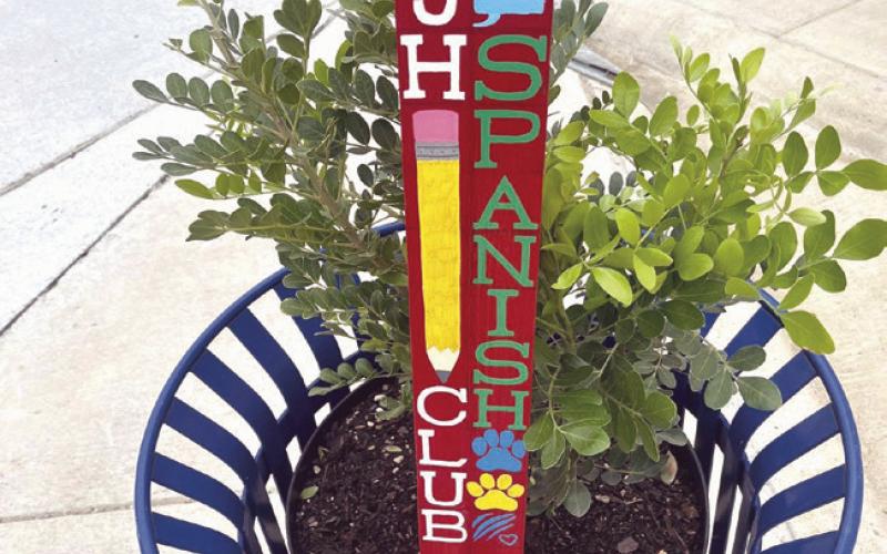 Olivia Schuch and Elizabeth Kelley receiving this year’s books. On the right, this is one of 18 planters which all have new plantings of Texas Mountain Laurels as well as Peace Posts.