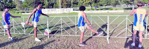 Above, the Tiger boys cross-country team prepares for the Hoka McNeil Invitational Friday in Round Rock. At right, Jon Fuller placed seventh out of 457 runners on the varsity level.