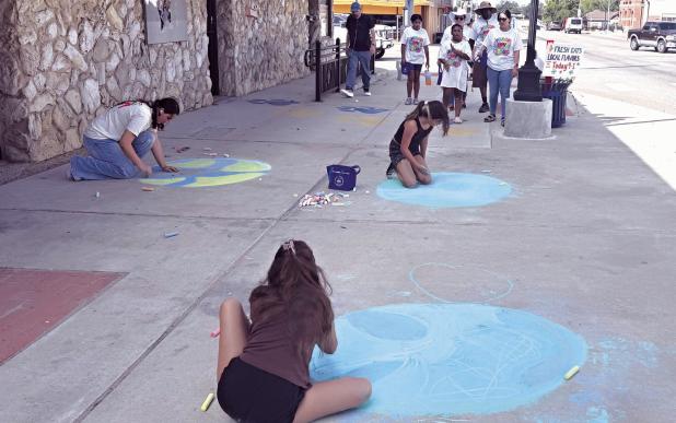 CHALK IT UP TO A GOOD TIME— Downtown Rockdale was the place to be on Saturday morning as organizations, individuals and businesses participated in Rockdale Earth Day’s International Day of Peace activities. Sidewalk chalk was handed out at Wolf Park and attendees were tasked with creating art promoting peace. More photos below and on page 6A.