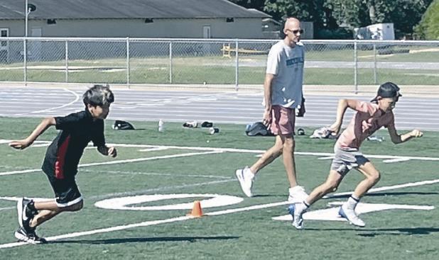 Tiger Coach Chase Rathke runs Rockdale Junior High athletes through some summer football drills last week. Reporter/Ken Ansell