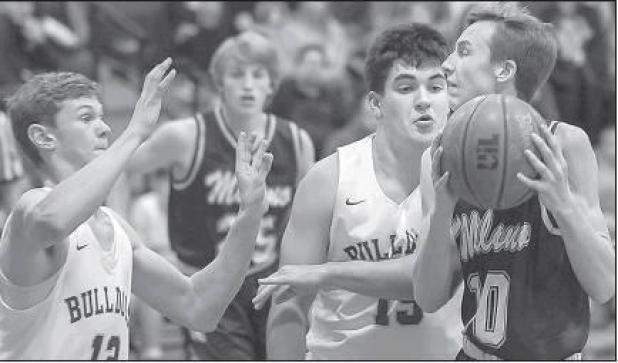 Photo by Steve Young Milano’s Layne Telg (right) tries to drive on Thorndale’s (left) Logan Davis and Jagger Rubio as Eagle Cordell Spears looks on, during the Feb. 11 matchup.