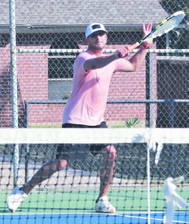 Rockdale tennis alumni Abram Maldonado, Class of 1998, returns a serve on Saturday at the city park courts. Reporter/ Nathan Flores