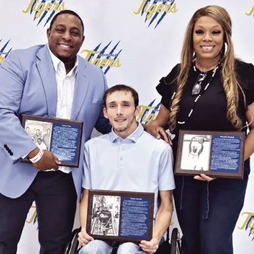 Rockdale’s 2026 Athletic Hall of Honor inductees were recognized during an Oct. 23 ceremony. Pictured standing, from left, are Decius Tasby, Class of 1998, and Sharee Mitchell, accepting on behalf of her son, Wendell Mitchell, Class of 2015, who was unable to attend. Seated is inductee Dustin Strelsky, Class of 2016. Rockdale ISD photo