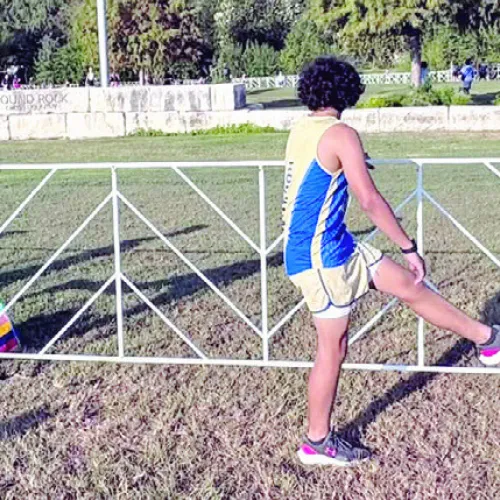 Above, the Tiger boys cross-country team prepares for the Hoka McNeil Invitational Friday in Round Rock. At right, Jon Fuller placed seventh out of 457 runners on the varsity level.