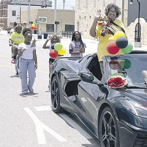 CELEBRATING FREEDOM— Rockdale’s Juneteenth Parade Grand Marshall Freddie Robertson waves to the crowd on Saturday as the parade wound down Cameron Avenue on its way to Sumuel Park. At the park were food, drinks, bounce houses, water slides and music to enjoy. Parade organizers Kendra Darnell Lewis and Larry Wilcox had more participants in the parade than in years past. See more photos on page 10A.