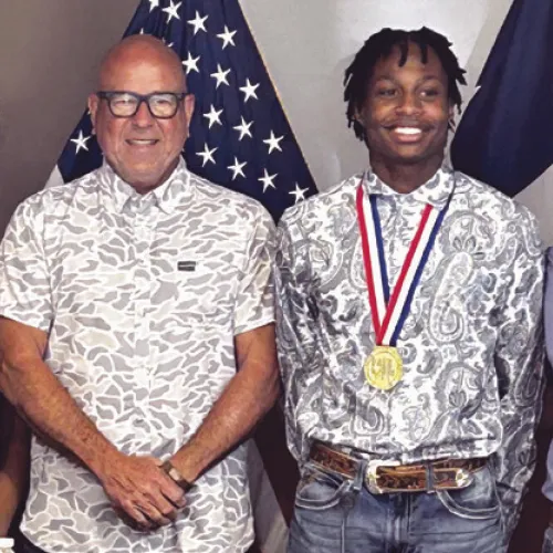 Mayor Ward Roddam read a proclamation honoring Rockdale High School Tiger D’Andre Stephens who scored a gold medal in the UIL Class 3A high jump competition with a 6-foot, 10-inches. They are flanked by DaJoria “DaeDae” Lister and coach Rene Muniz.
