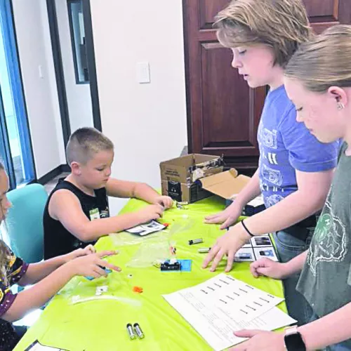 Noah Bradley and Abigail Bradley teaching robotics to Cloverbuds Anna Kroeger and Briggs Berry.