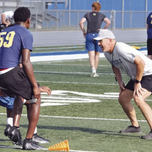 Coach Brent Hasselbach shares his coaching experience with Tiger players during Saturday morning practice at Tiger Stadium. Reporter photo by Nathan Flores