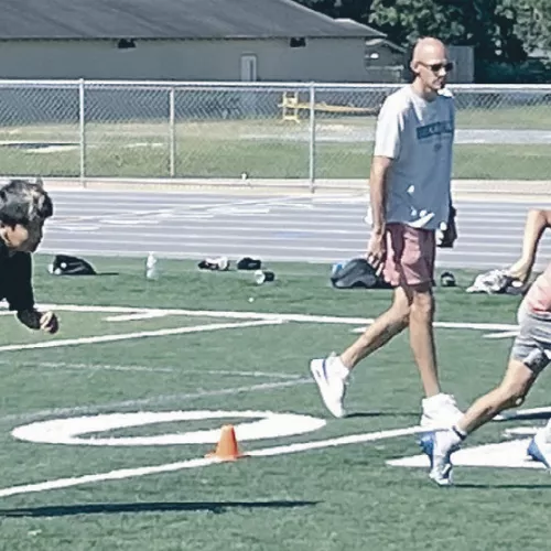 Tiger Coach Chase Rathke runs Rockdale Junior High athletes through some summer football drills last week. Reporter/Ken Ansell