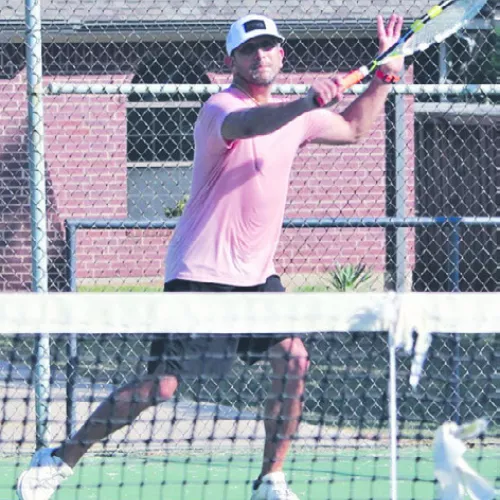 Rockdale tennis alumni Abram Maldonado, Class of 1998, returns a serve on Saturday at the city park courts. Reporter/ Nathan Flores