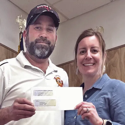 RVFD DONATIONS— Fire Chief James McQuinn accepts a $2,000 donation from Business Systems and Communications Associate Kayla Schnell. The volunteer fire department also recently received $15,000 from Cappolino | Dodd | Krebs LLP, $1,000 from Dale Throckmorton, and $1,500 from Pete and Nancy Zenner.