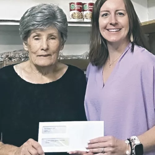 Patsy Brymer, left, Rockdale Christian Services food pantry director and board president, accepts a $5,000 donation from Kayla Schnell, Sandow Lakes Ranch Business Systems and Communications Associate.