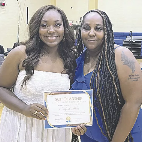 Golden Girls Scholarship T’Niyah Miles receives $1,000 from her mother and Golden Girls coach Vicky Miller.